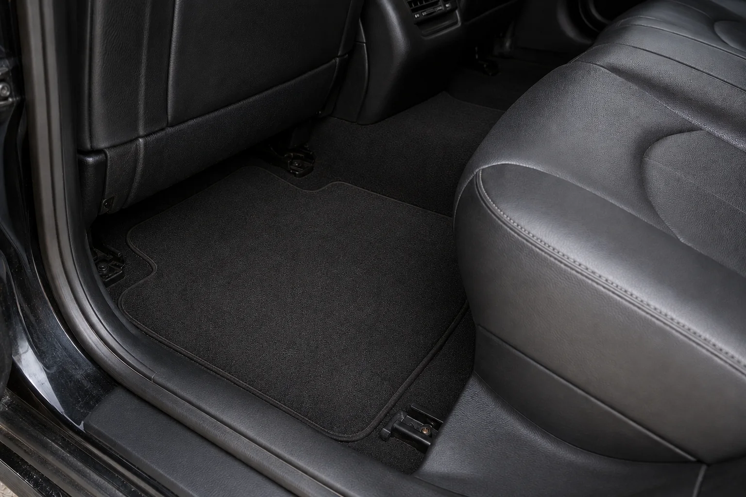 Restored black carpet and leather in a sedan rear footwell